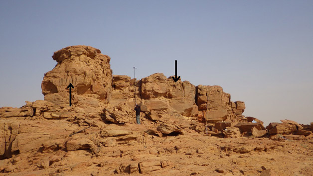 Éperon rocheux au centre et à la gauche duquel on peut distinguer des reliefs rupestres de dromadaires.