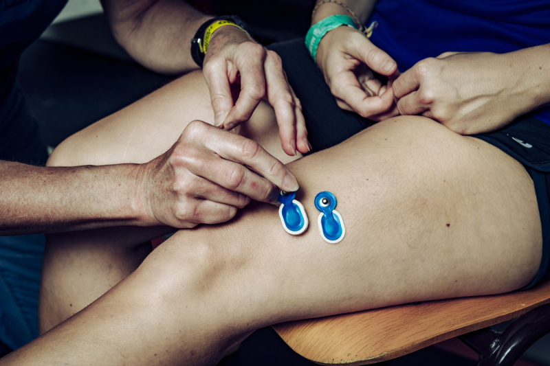Fitting electrodes to record muscle activity in a sportswoman's lower limb