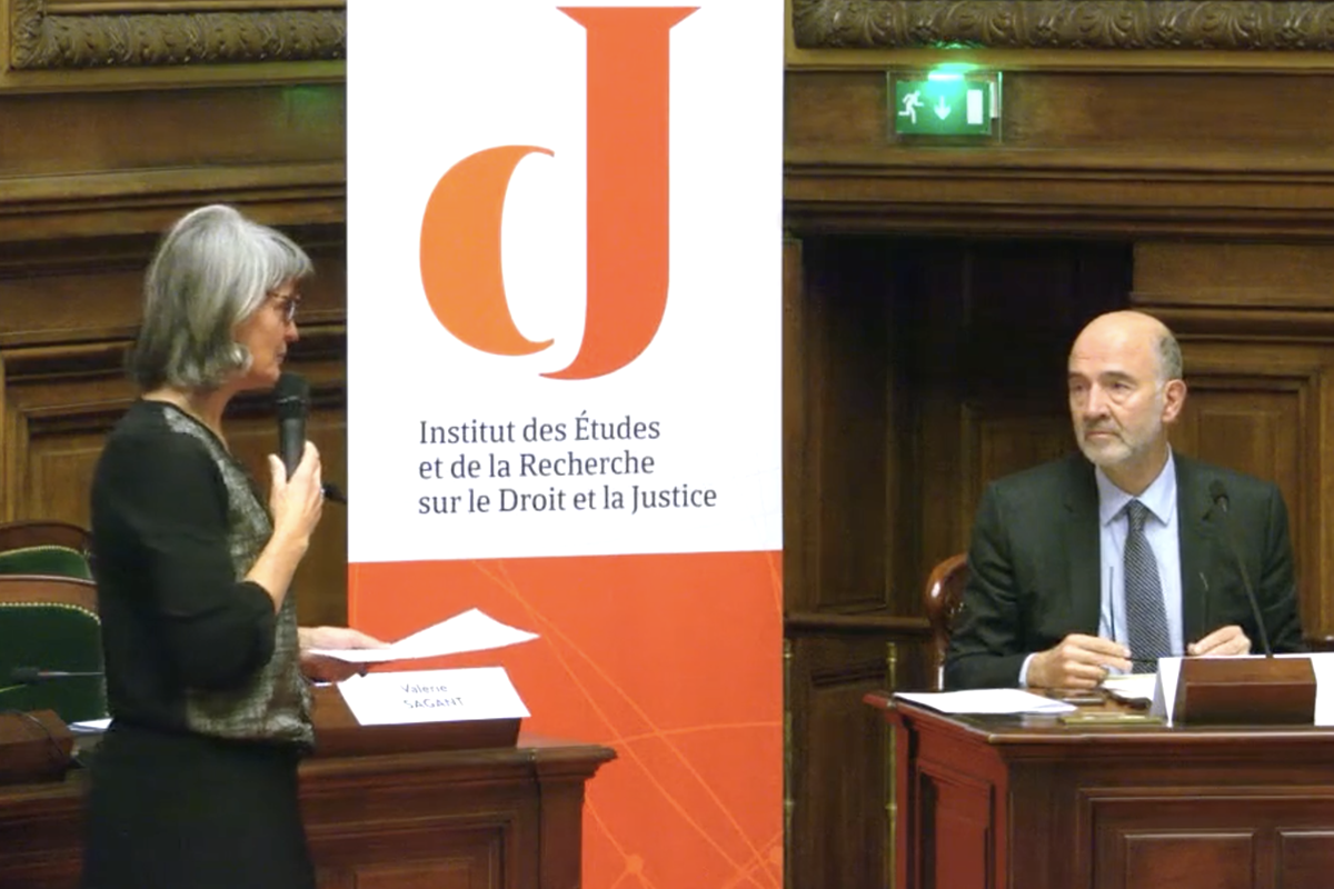 Valérie Sagant debout au micro, face à Pierre Moscovici assis