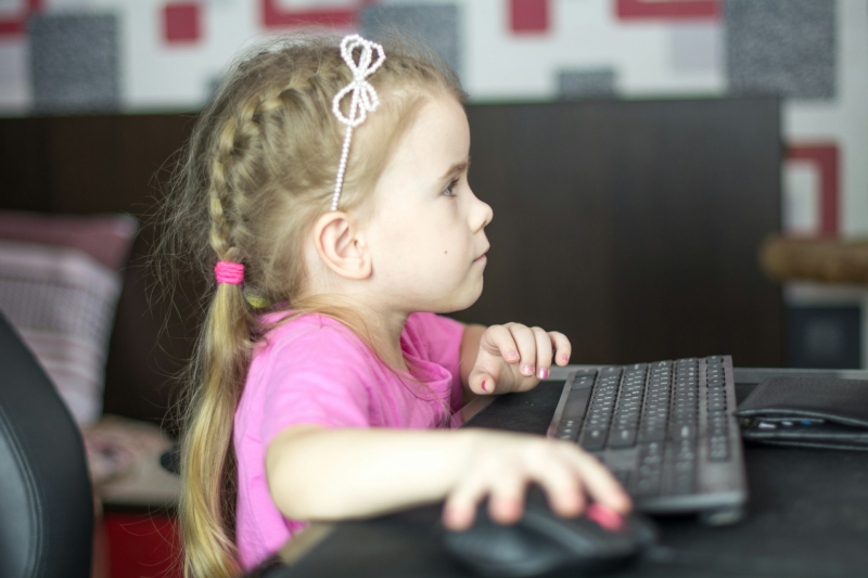Une petite fille devant un écran d'ordinateur