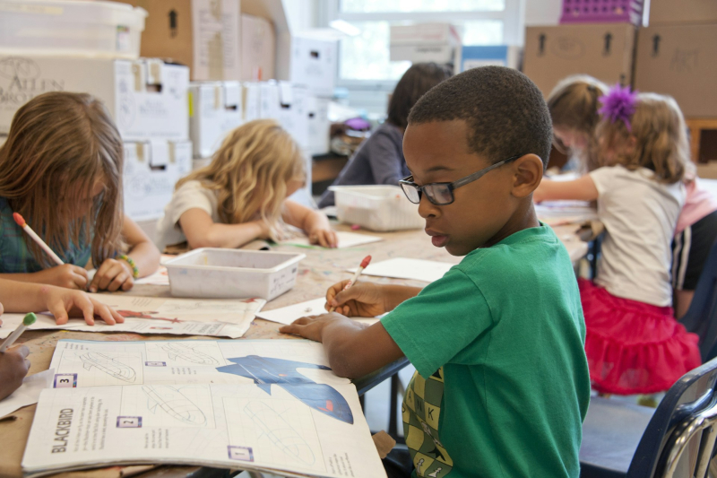 Un garçon écrivant à l'école.