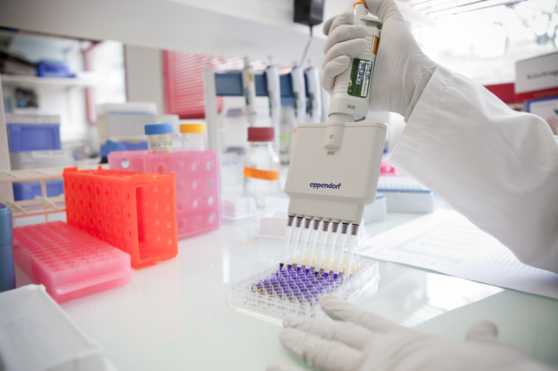 Une personne utilise des pipettes.