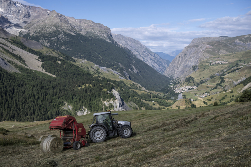 Tracteur rouge avec un paysage alpin en arrière-plan
