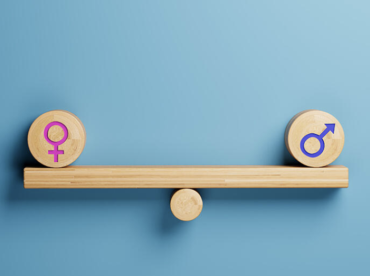 Une balance en bois avec un symbole masculin et un symbole féminin de chaque côté