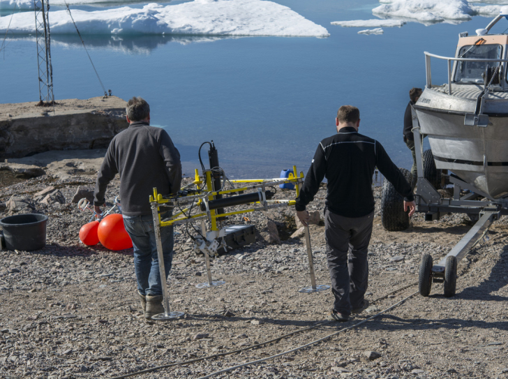 Des scientifiques mettent à l'eau un courantomètre, au Groenland