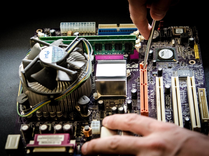 Une personne démonte un circuit électronique