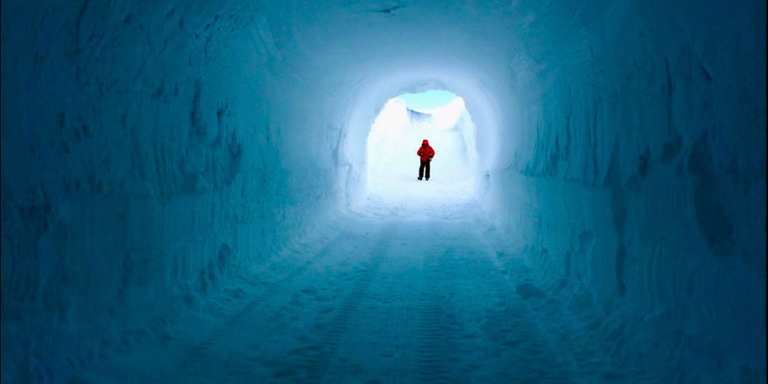 Un homme à l'entrée, au loin, du ice cave Memory santuary