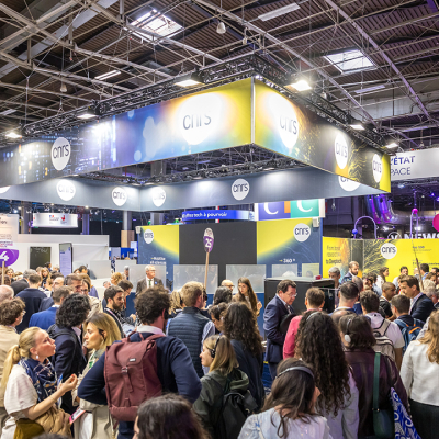 stand CNRS VivaTech 2024 ; intérieur jour, foule de personnes au premier plan, plafond avec fenêtres carrées et armature métalliques
