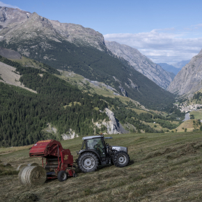 Tracteur rouge avec un paysage alpin en arrière-plan